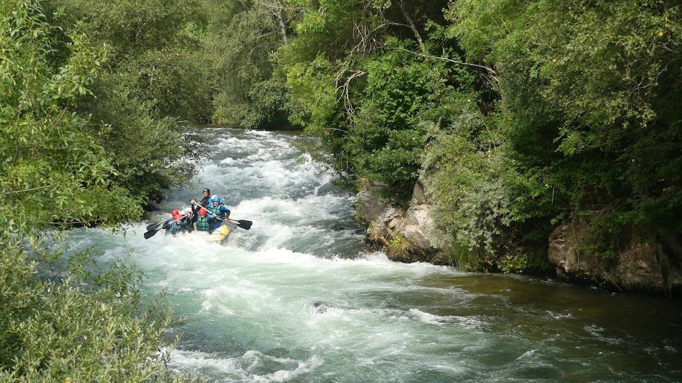 Grupo descentiendo ríos bravos en rafting por el río Curueño cerca de León