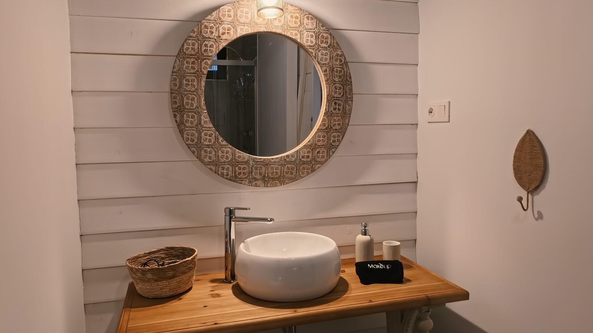 Baño de Casa Braña con lavabo de piedra y espejo redondo