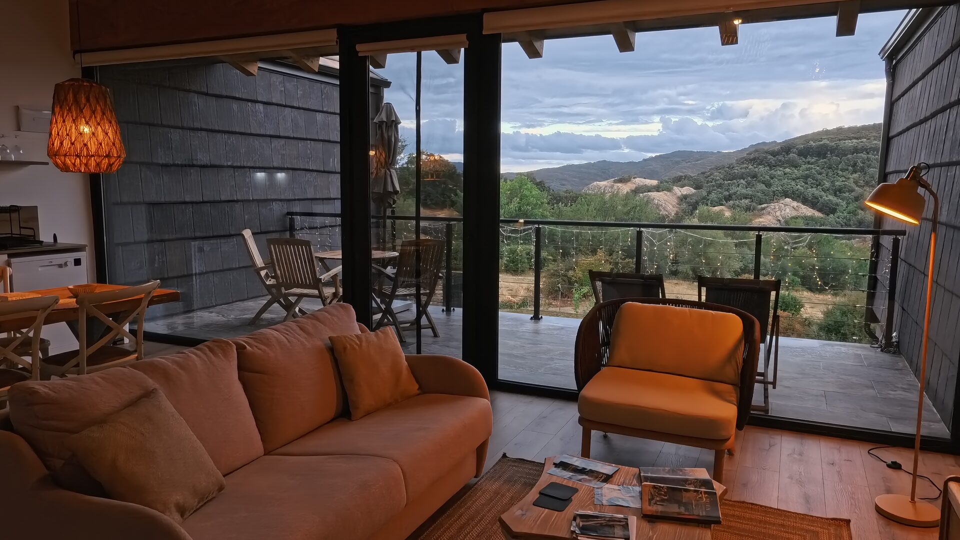Sofá del salón de Casa Braña frente al ventanal abierto a la terraza
