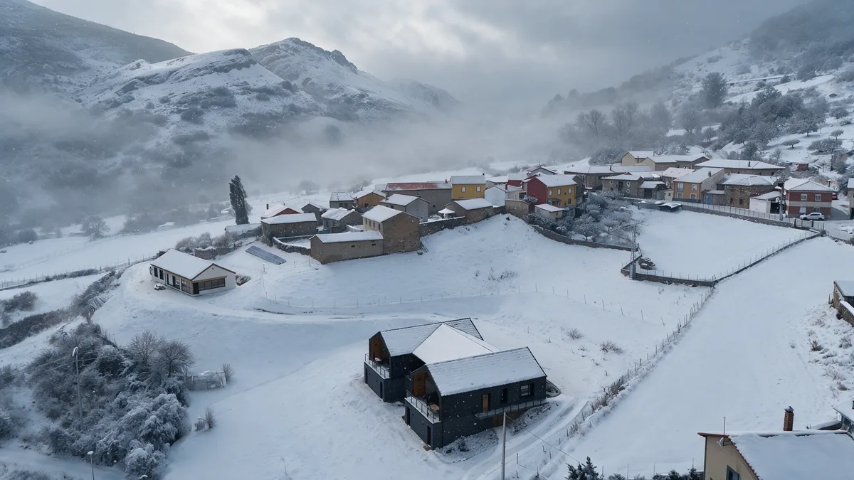 Niebla sobre el Valle de Vegacervera nevado, con las casas rurales en primer término, vista aérea de invierno