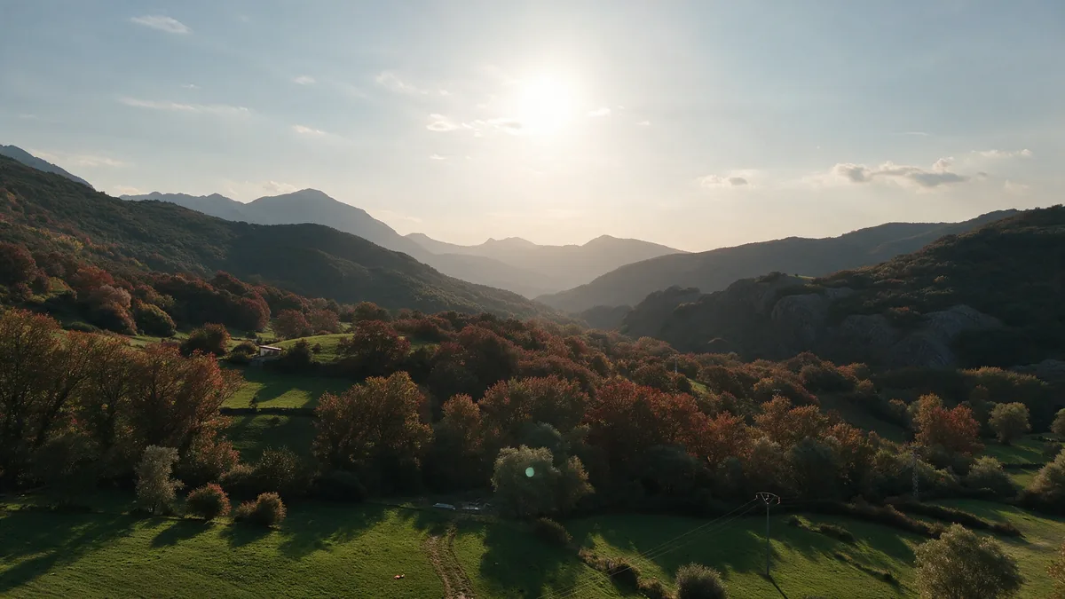 El Valle de Vegacervera a contraluz en otoño, con los bosques rojizos y la montaña al fondo